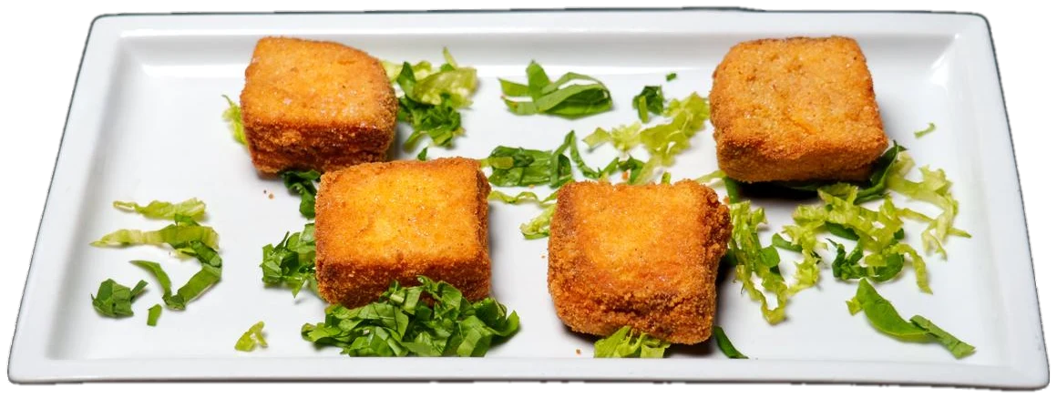 Quadrotti fritti dorati su piatto rettangolare con lattuga e basilico